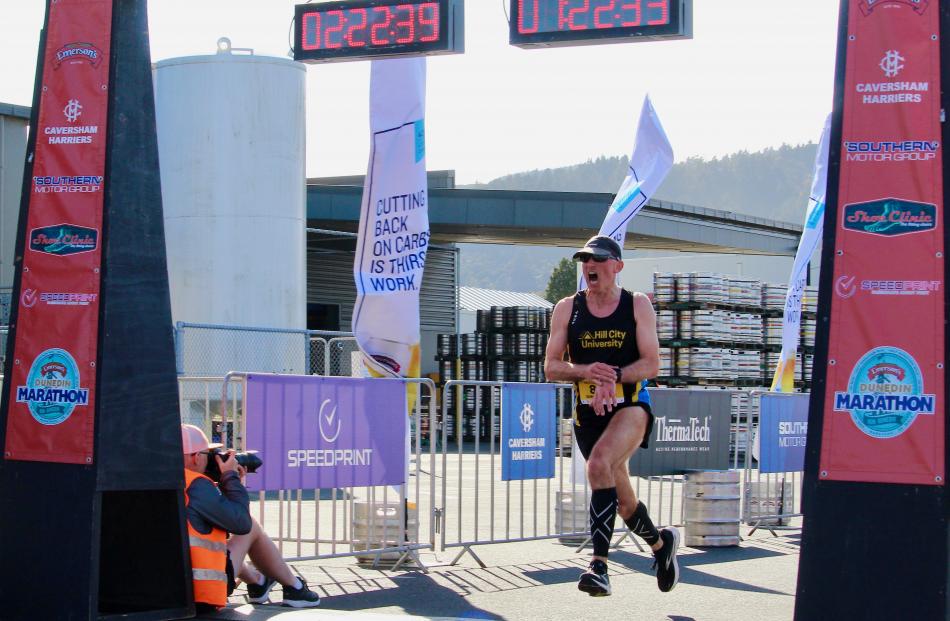 Simon Rhodes roars with success as he crosses the finish line after completing the half marathon...