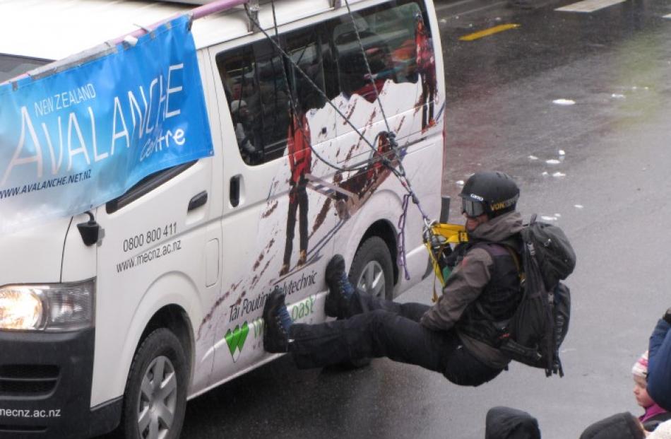 A man hangs from the side of the New Zealand Avalanche Centre van during the Queenstown Winter...