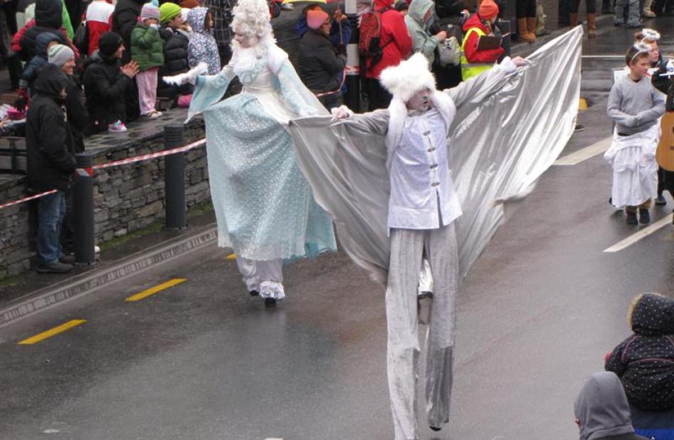 Children wave to the crowd from a float in the Queenstown Winter Festival Street Parade on...