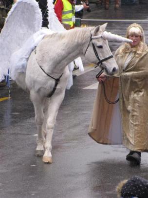 Zoe Clear, from Queenstown, leads a unicorn along the Camp St. Photo by Christina McDonald.