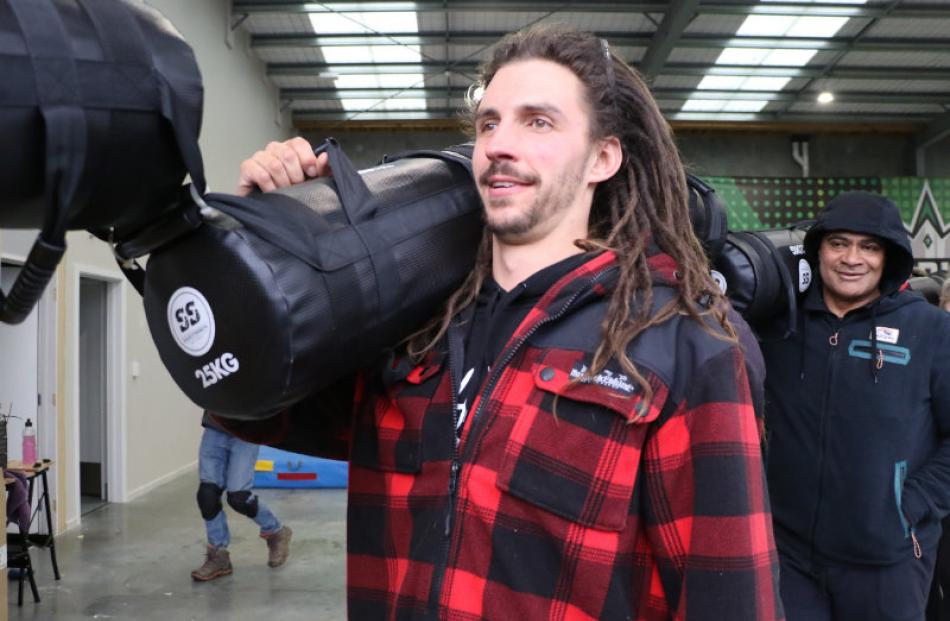 Tom Ickenroth of Rangiora joins a procession of  participants carry 25kgs bags  at the Saints...