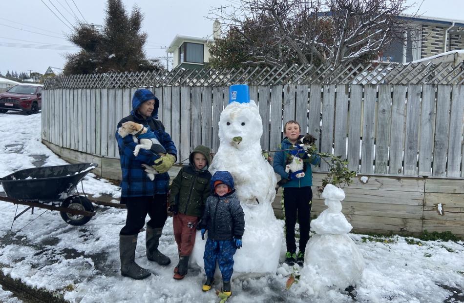 Having fun building a snowman in Brockville are Conan Newbury, Max the dog, Lukas Newbury with...