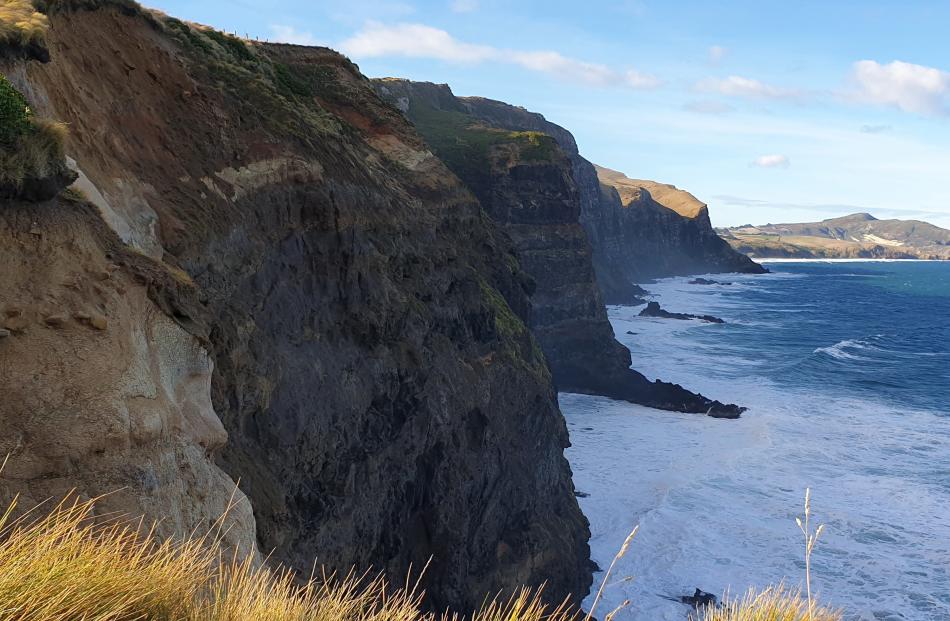Tall, dark, daunting cliffs mark the coastline north of Smaills Beach.