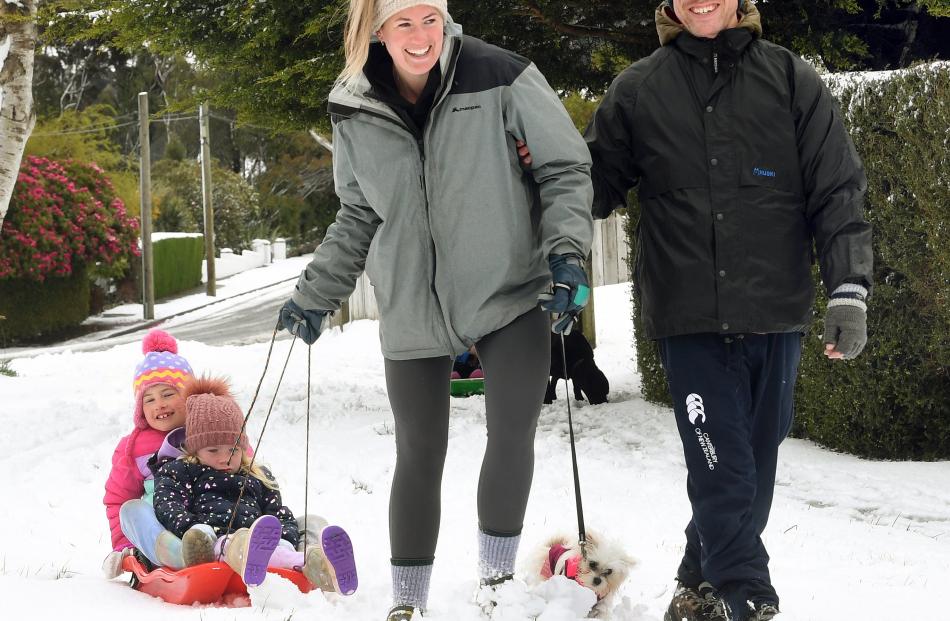 Looking forward to warming up with hot cocoa, Kate Duder pulls Ava Gardiner (4) and Charlotte...
