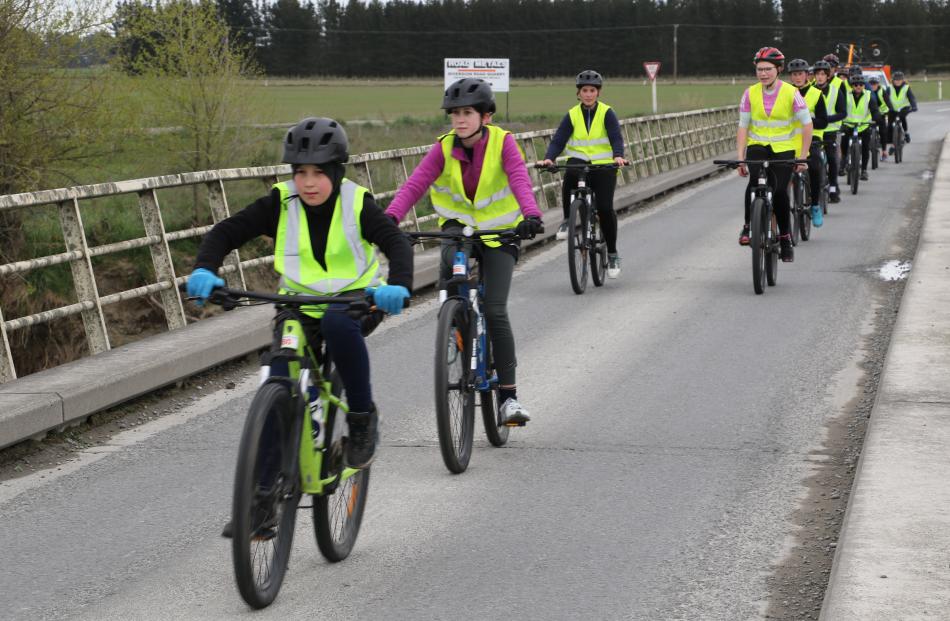 Long way home  . . . Connor Newby 15, leads the Kaiapoi High School cyclists over a road bridge....