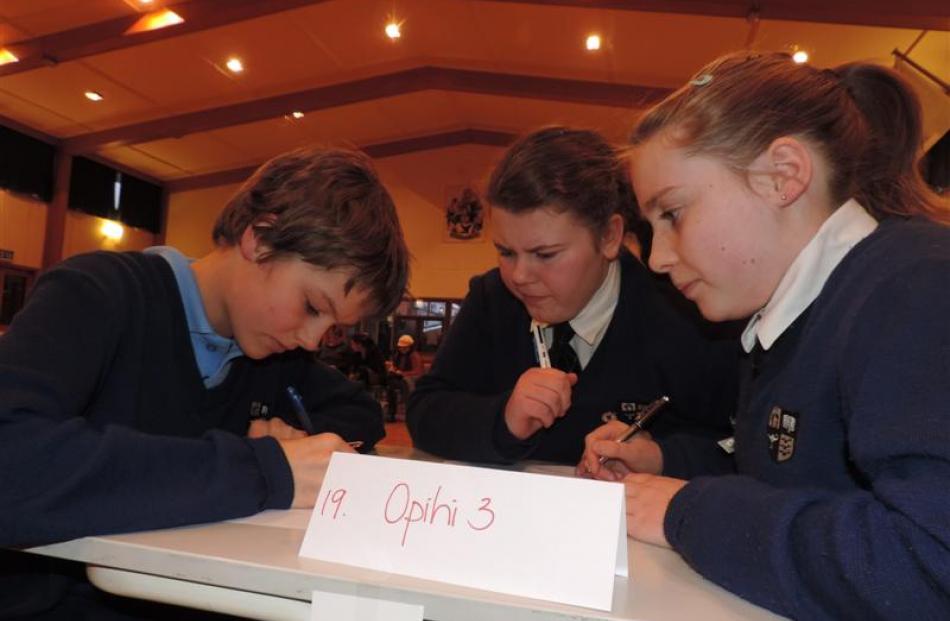 Concentrating on their answer are (from left) Will Johnson (13), Ellen Crosse (13) and Dana...
