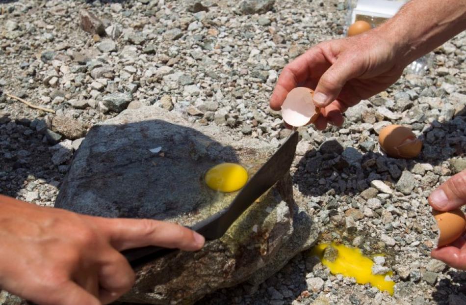 Bengt Jonsson tries to fry an egg on a rock as temperatures in Badwater Basin reach 53degC ...
