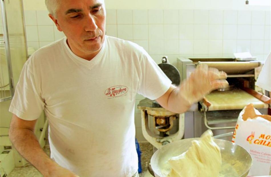 Baker Carlo Creanza, of La Maggiore bakery (left),  weighs the dough for the famous pane di...