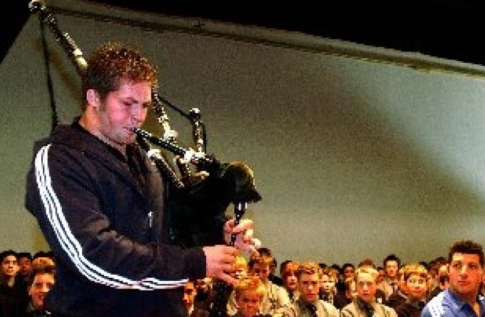 Richie McCaw plays the bagpipes and fellow All Black Byron Kelleher looks on during an assembly...