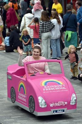 A Barbie pink car runs along George St.