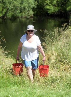 Jill Oats, of Dunedin, collects buckets of water for cooking from the river at Bucklands Crossing.