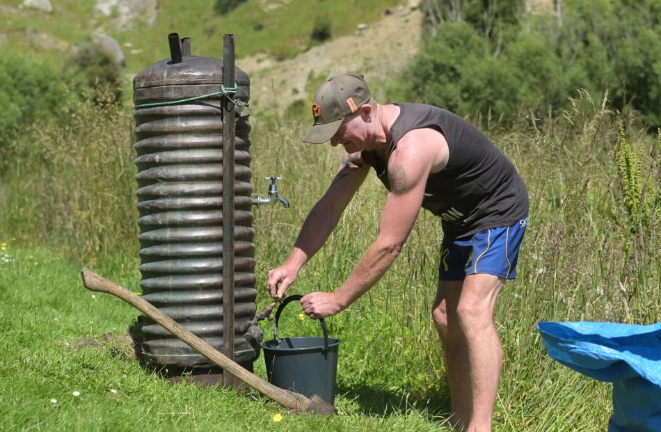 Phil Bain, of Dunedin, takes hot water from a giant thermette.