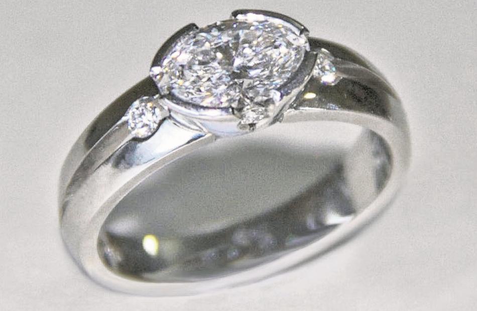 Platinum ring with one large oval and four small diamonds by Tony Williams.