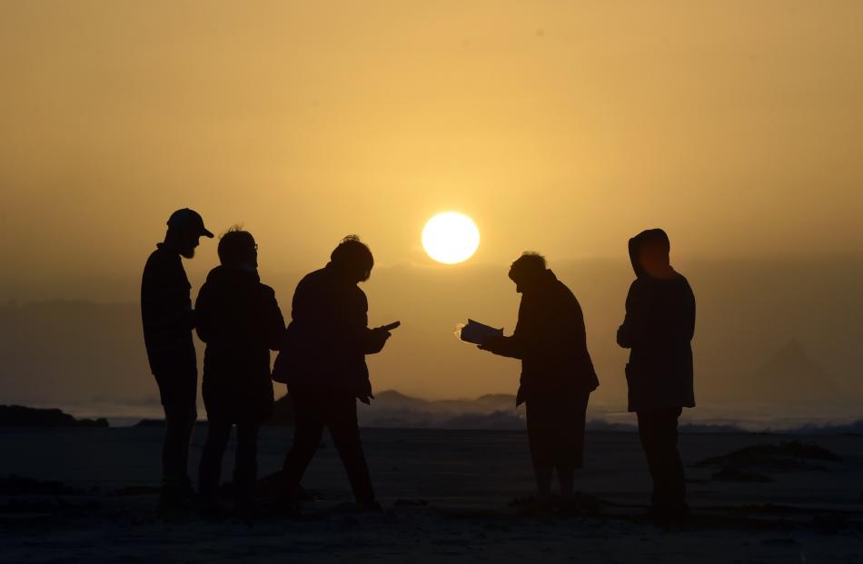 Members of St Margaret’s Church worship at sunrise on Brighton Beach on Easter Sunday.