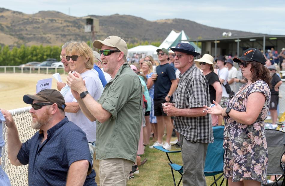 The crowd watches on as horse number three Sophie wins race three.