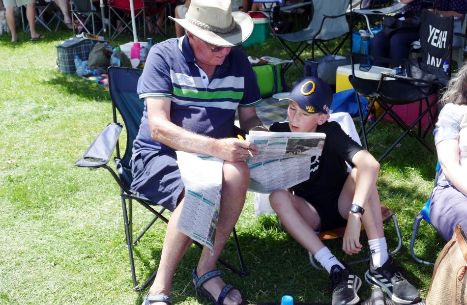 Barry Hambleton and grandson Max Hambleton (12) check the form at the Omakau races on January 2....