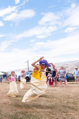 Henry Pine (7), of Invercargill, leaps towards the finish of the children’s sack race.