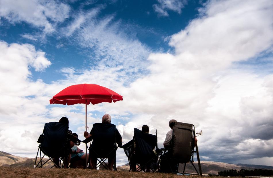 Punters watch the action as the weather begins to turn.