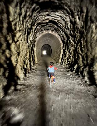 Jamie Cartwright (5), of Dunedin, rides through one of the rail trail tunnels near Lauder. PHOTO:...