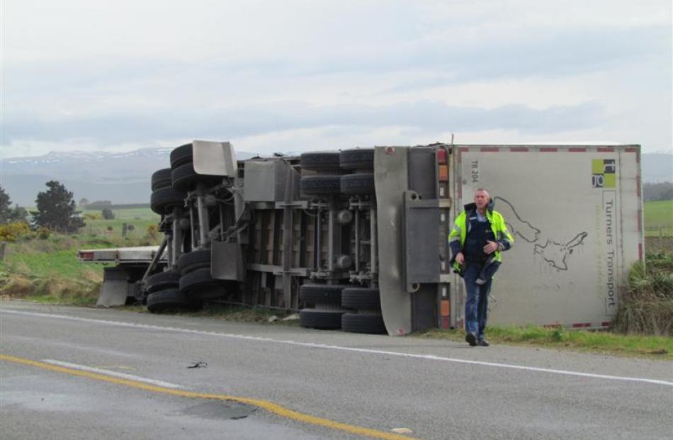 A truck lies facing the opposite way it was heading on State Highway 1, after being blown over....