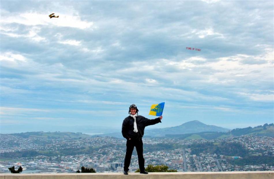 Dunedin North Labour MP David Clark flies his flag  at Signal Hill as a Tiger Moth tows a ''Stand...