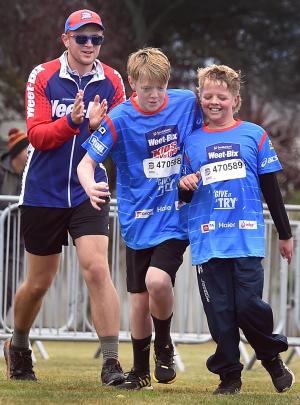 The Michael brothers of Mosgiel, Adam (12, left) and Daniel (11) help each other across the...