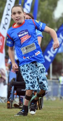Matthew Russell (12), of Mosgiel, jumps out of his wheelchair to cross the finish line.