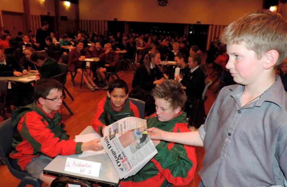 Timaru Boys' High School's Charlie Stock (13) hands a newspaper to the Ashburton Intermediate 2...