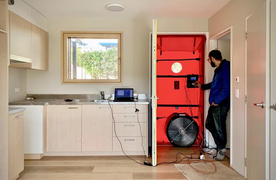 A calibrated fan is installed in a door to measure how much air is entering or escaping from one...
