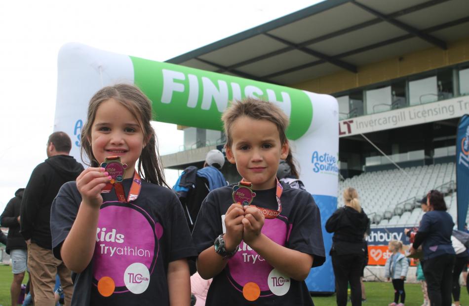 Twins, Sarah and David Jenkins (6), proudly display their medals after completing the Total Life...