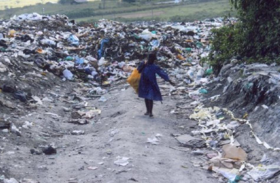 A girl carries items scavenged from a rubbish tip in Nakuru. Photos by Craig Baxter and supplied.