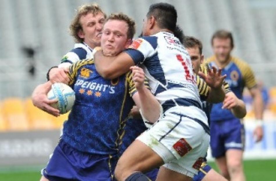 Otago's Gareth Evans is tackled by Auckland's Hadleigh Parkes (left) and Malakai Fekitoa during...