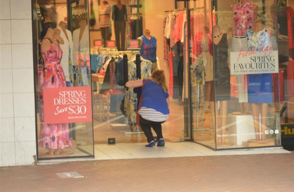 A woman closes the doors on a retail business in George St  after the gas leak required the...