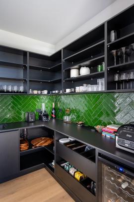 A dark bench top and a bold green tiled splashback feature in the scullery. PHOTO: SAMPFORD CATHIE