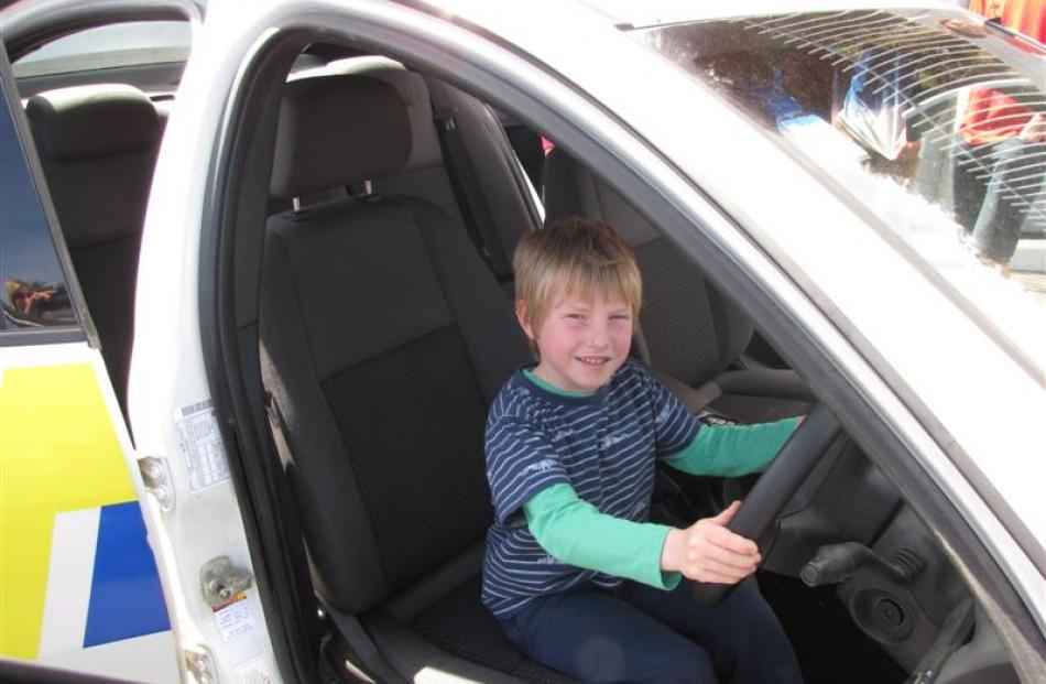 Xander Maguire (5), of Wanaka,  tries out the driver's seat of a police car. Photos by Lucy...
