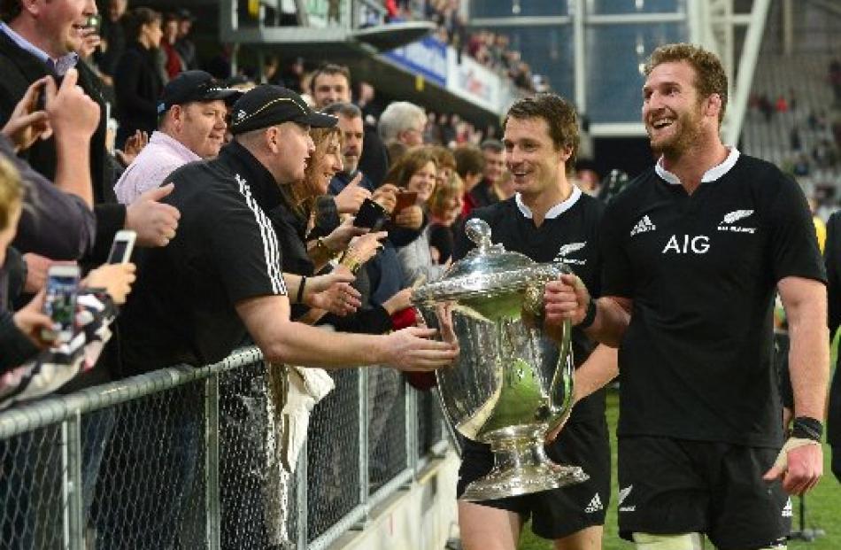 Ben Smith and Kieran Read, with the Bledisloe Cup, greet members of the crowd after the match.