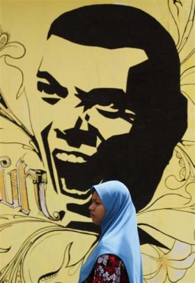 A Muslim woman walks past presidential candidate Mohamed Nasheed's  election campaign poster in...