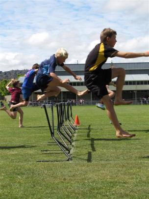Pupils compete in the boys under-12 hurdles.