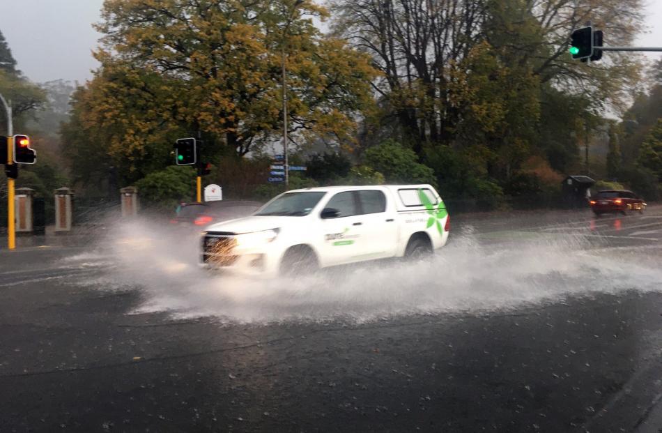A ute makes its way through a flooded intersection at the Gardens intersection. PHOTO: GERARD O...