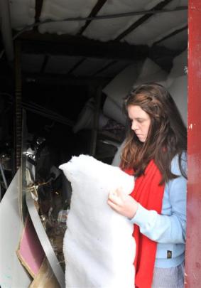 Letisha Nicholas (23), inspects the insulation used to line the basement. The material makes use...