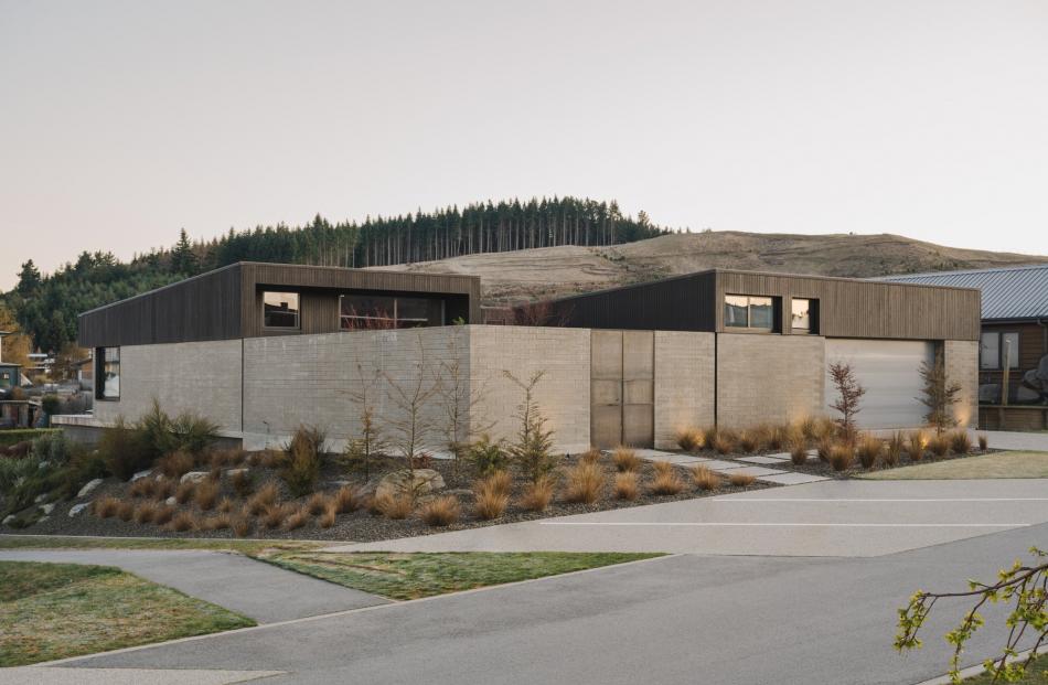 Clad in concrete block veneer and dark-stained cedar, both buildings are set around a courtyard...