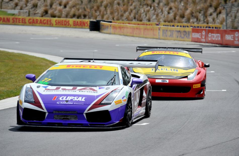 Australian GT series cars, a Lamborghini, followed closely by a Ferrari, corner hard during...