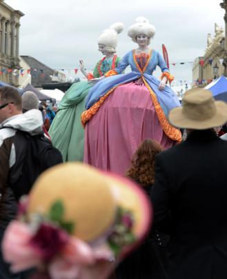 A pair of stilt walkers tower over the crowd.
