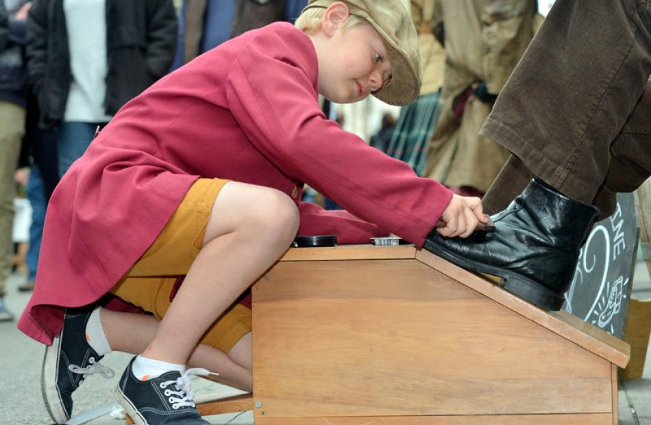 Frank Lory (9), of Oamaru, adds some sparkle to a client's boot at his shoe shine stall.