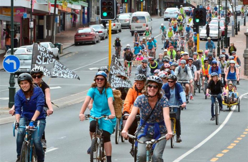 Drilling protesters cycle through the Exchange area in Dunedin yesterday.