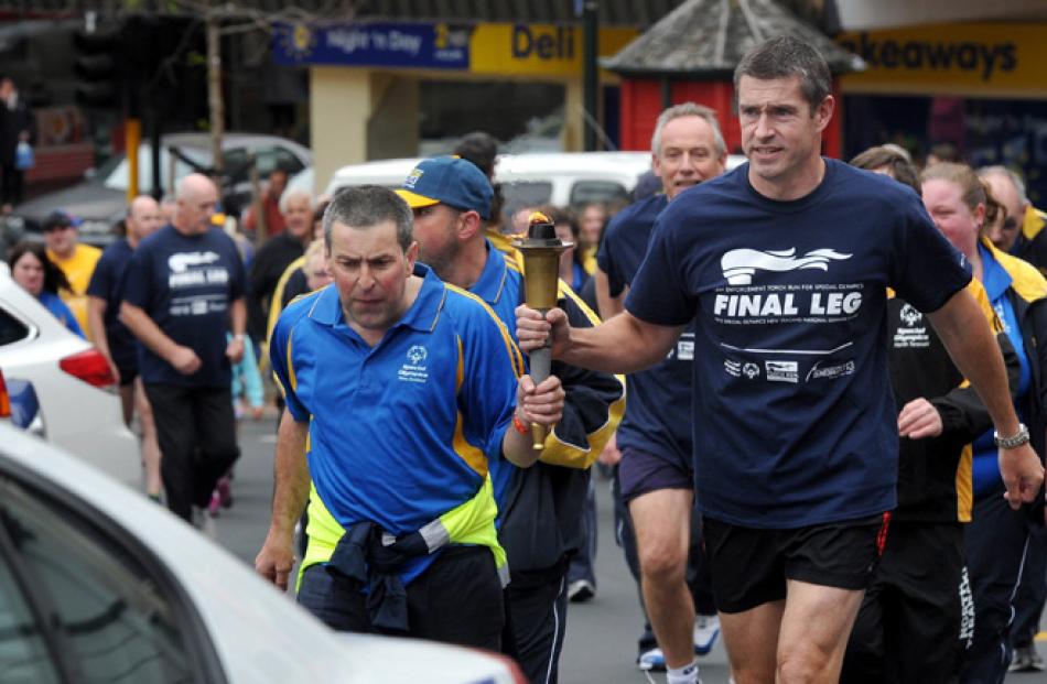 Dunedin golfer Shayne Anderson (44) runs with Southern District police commander Superintendent...