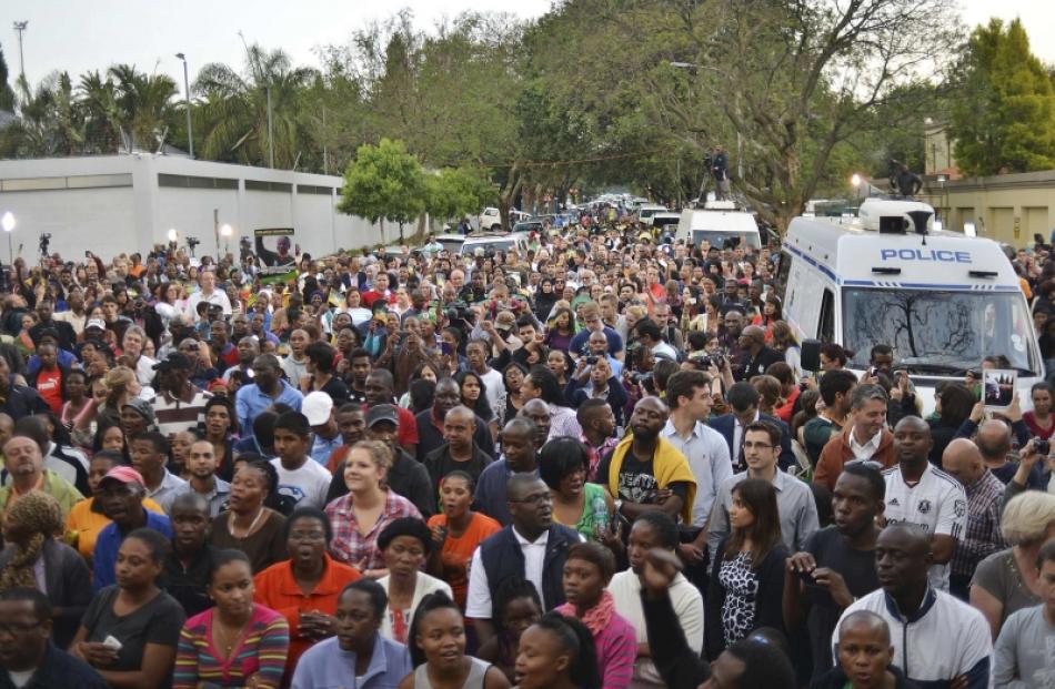 People flock to the late leader Nelson Mandela's Houghton home to lay down flowers and messages...