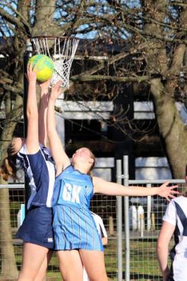 St Andrew's goal shoot Makenzie Disher soars above St Hilda's goal keeper for possession. Photo:...