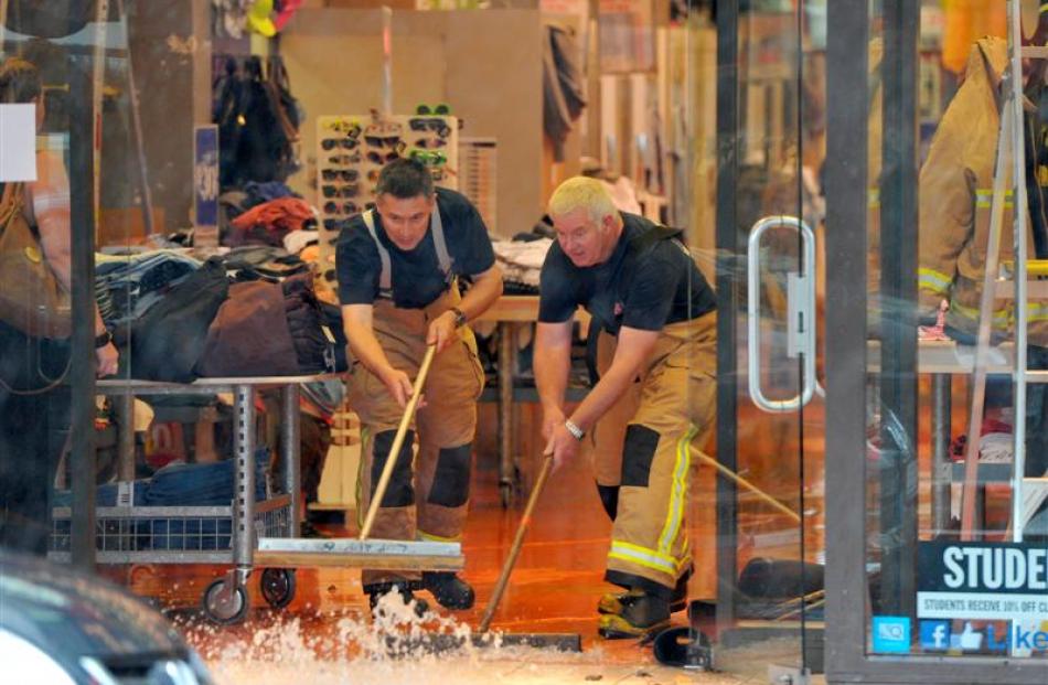 Lookout Point Senior Fire Officers Michael Loo (left) and Gerald Vorgers push water out of Jay...
