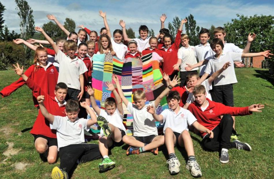 Room 10 pupils from Fairfield School with a blanket they knitted for the Child Cancer Foundation.